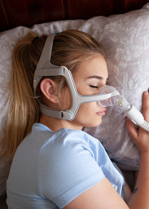 A woman using a CPAP machine while sleeping.